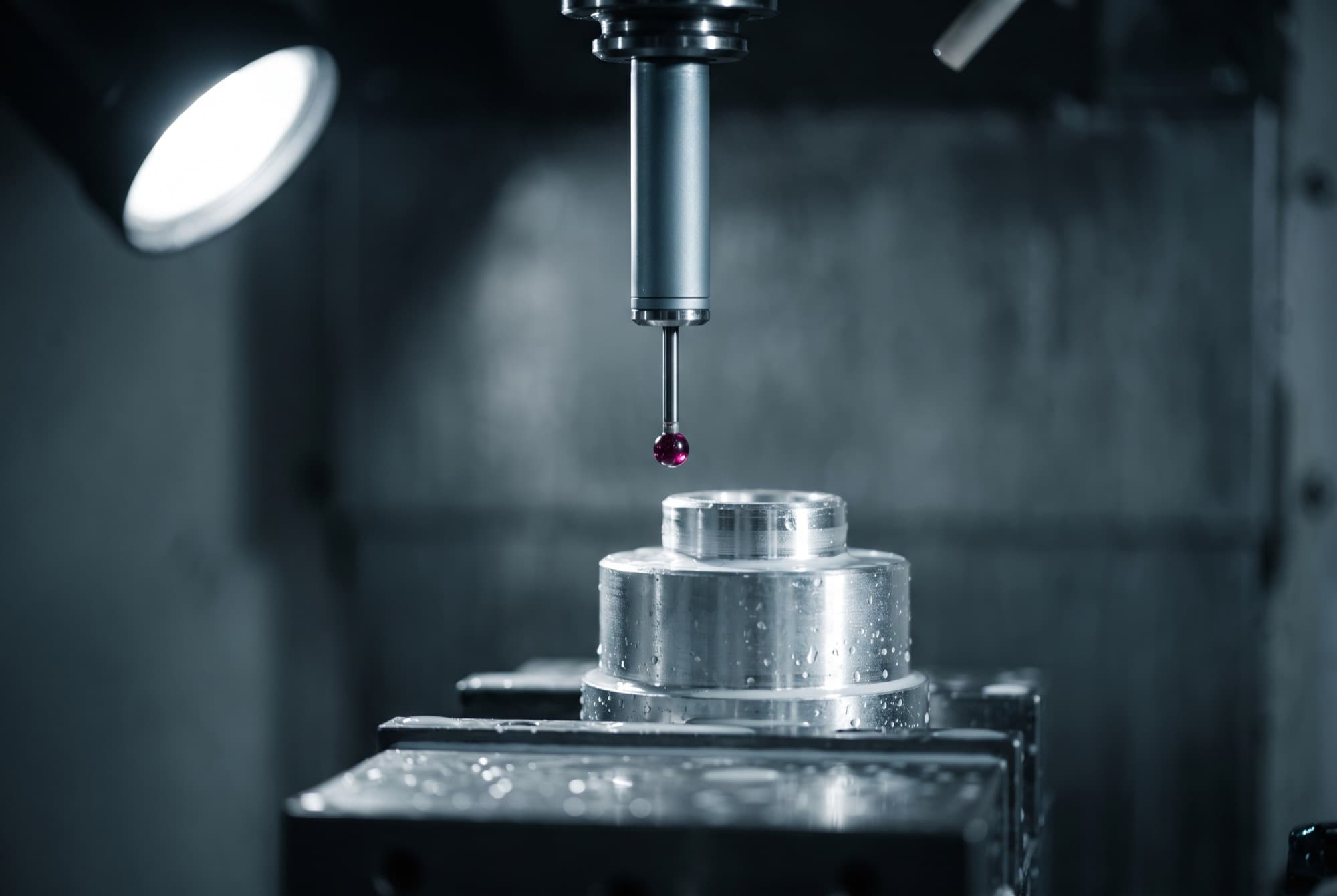 A touch probe in a machine spindle taking a measurement on a fixtured part inside a vertical machining center.